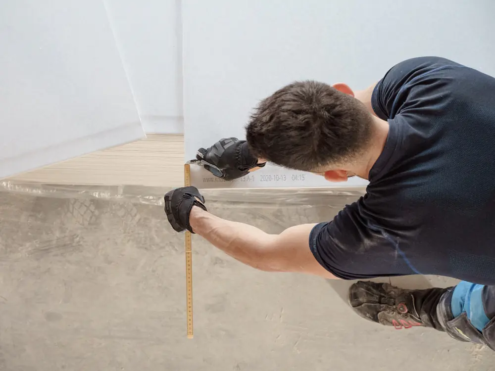 Vakman meet hout op met een rolmaat