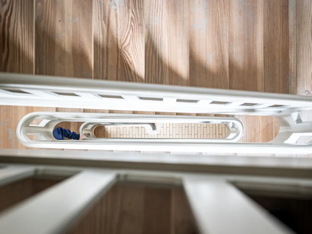 Spiltrap met houten treden en een witte leuning