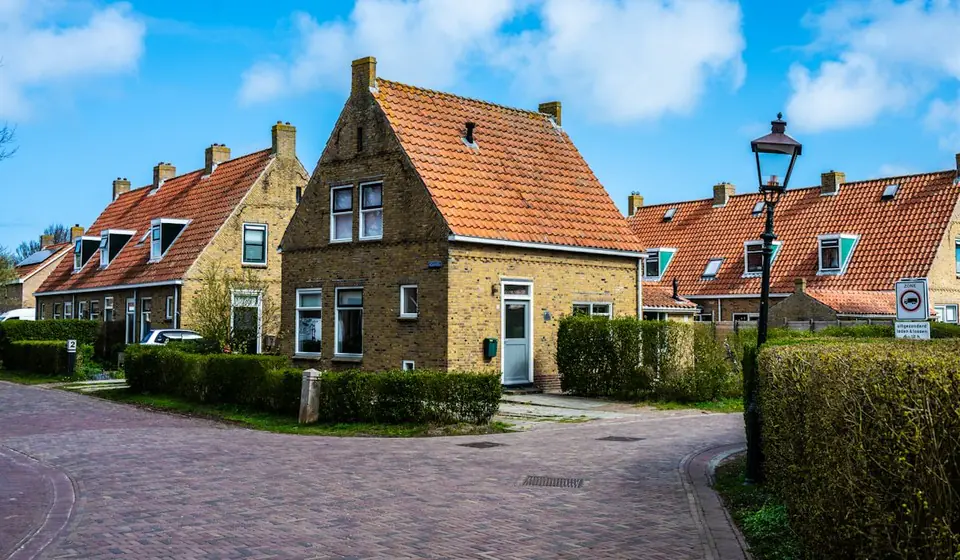 Rij Nederlandse baksteenwoningen met oranje dakpannen